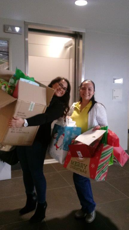 Emely Cordon and Isabel Felix delivering gifts from Hellas to families through the Blue Santa program.