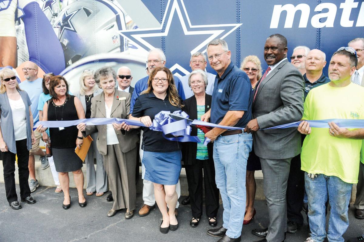 Ron Norsworthy, the director of manufacturing for Hellas, cuts the ribbon to commemorate a third expansion at Hellas’ Dadeville plant, which manufactures the base material for artificial turf. The Dallas Cowboys’ stadium is among the NFL venues using Hellas turf. Hellas has added 30 jobs and $2.6 million in new equipment in Dadeville.